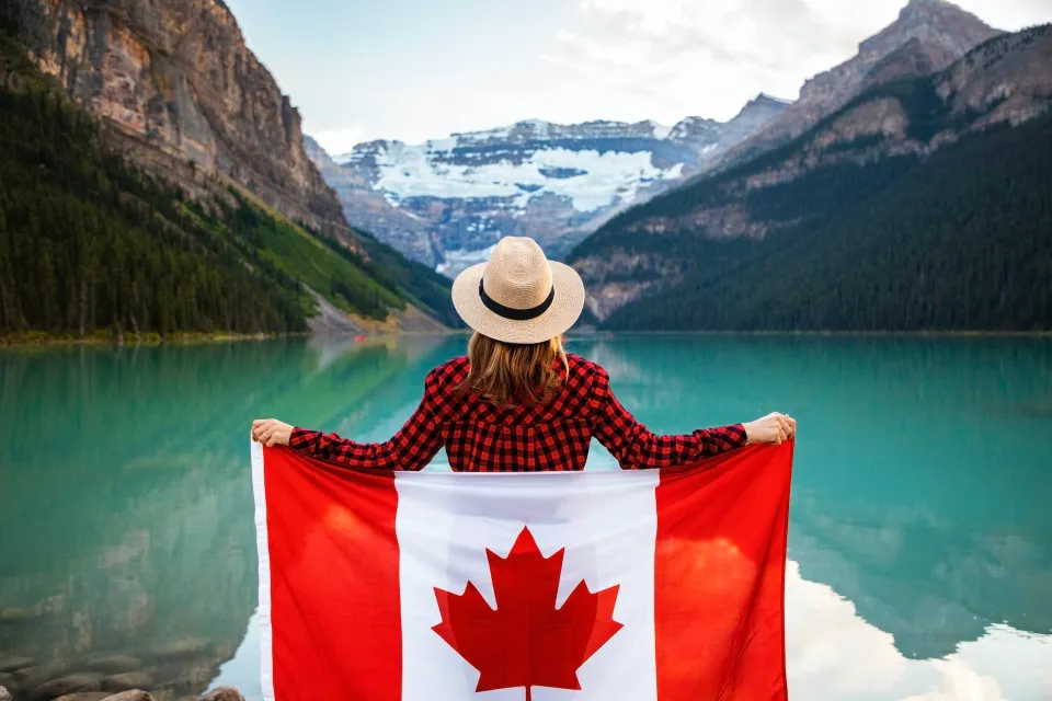 A lady holding Canadian flag at here back