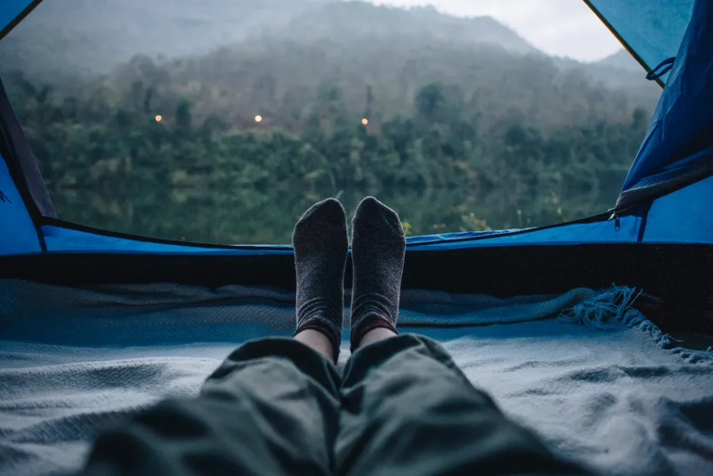 A woman sleeping in a camping tent with an amazing view